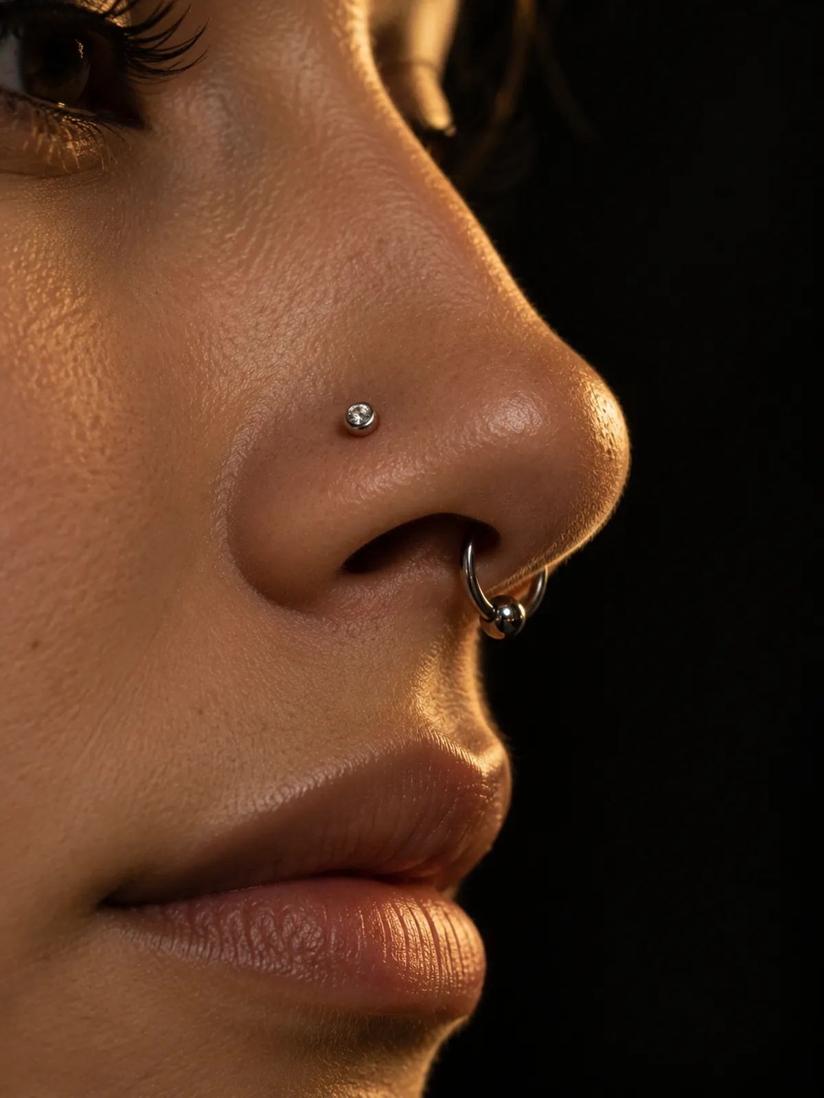Nez de profil portant un anneau de septum et un nostril serti
